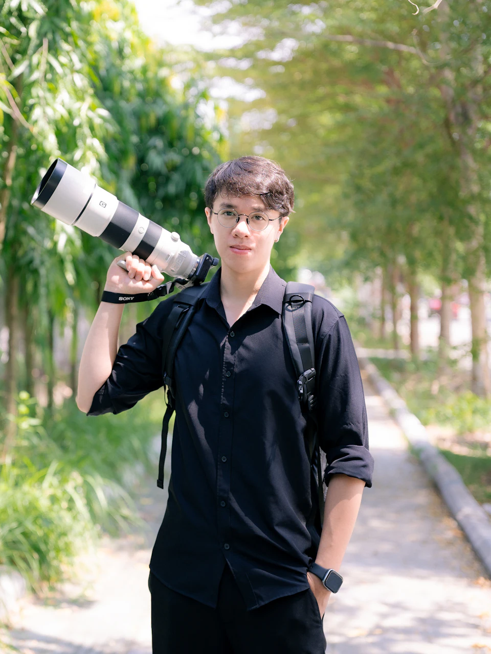 A photographer carrying a camera with a long lens